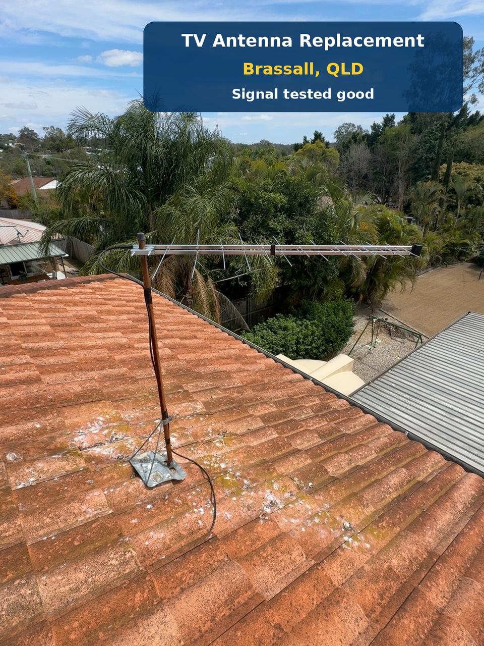 Replacement TV antenna with its mast and cable on a terracotta tiled rooftop at Brassall